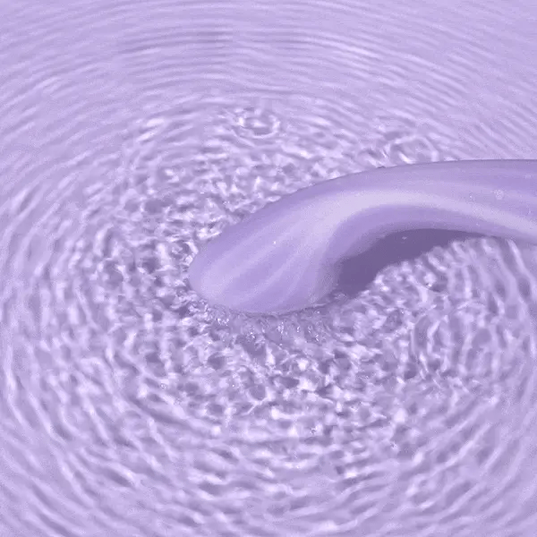 Close-up of a roll of purple toilet paper with water droplets on the surface.